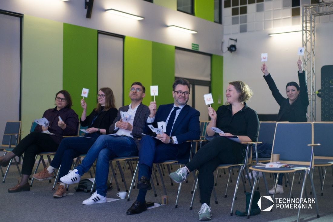 Jury hackathonu ocenia prace, unosząc karty z punktami